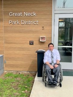 Charles Fulham sitting in a wheelchair in front of the Great Neck park District building