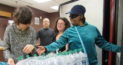 Two girls handling a package of water bottles
