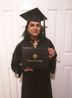 A woman named Divya wearing a cap and gown and holding a Valencia College diploma case