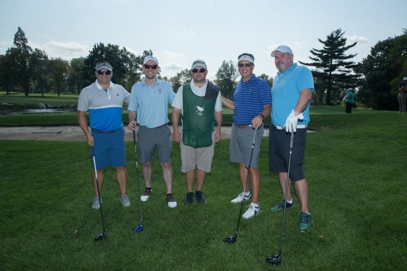 Five men on a golf course.