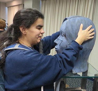 Woman touching sculpture of a large head