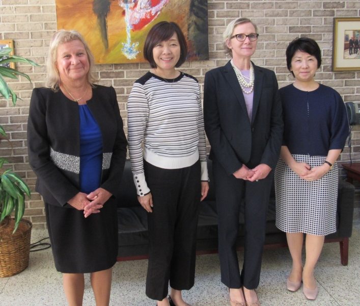 Group of women smiling and wearing business attire