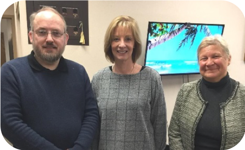 One man and two women smiling