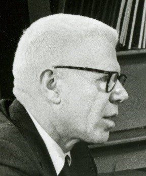 The side view of Louis J. Bettica wearing a suit, tie, and glasses