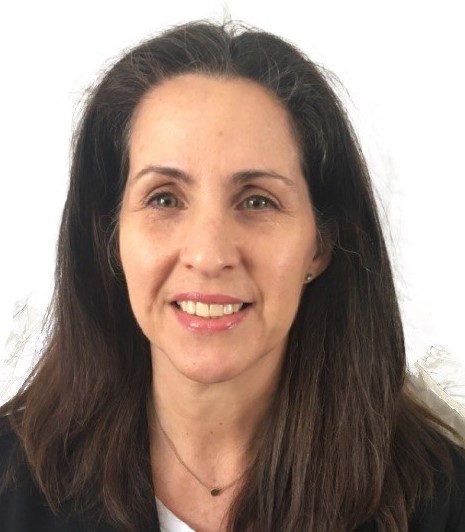 Head shot of a woman with light skin and long brown hair parted in the middle