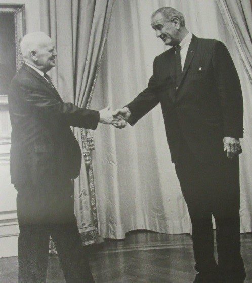 Peter J. Salmon shakes hands with President Lyndon B. Johnson. Both men are standing and wearing suits.