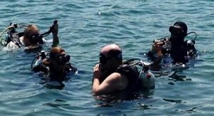 Scott prepares to dive in the ocean with a group of people