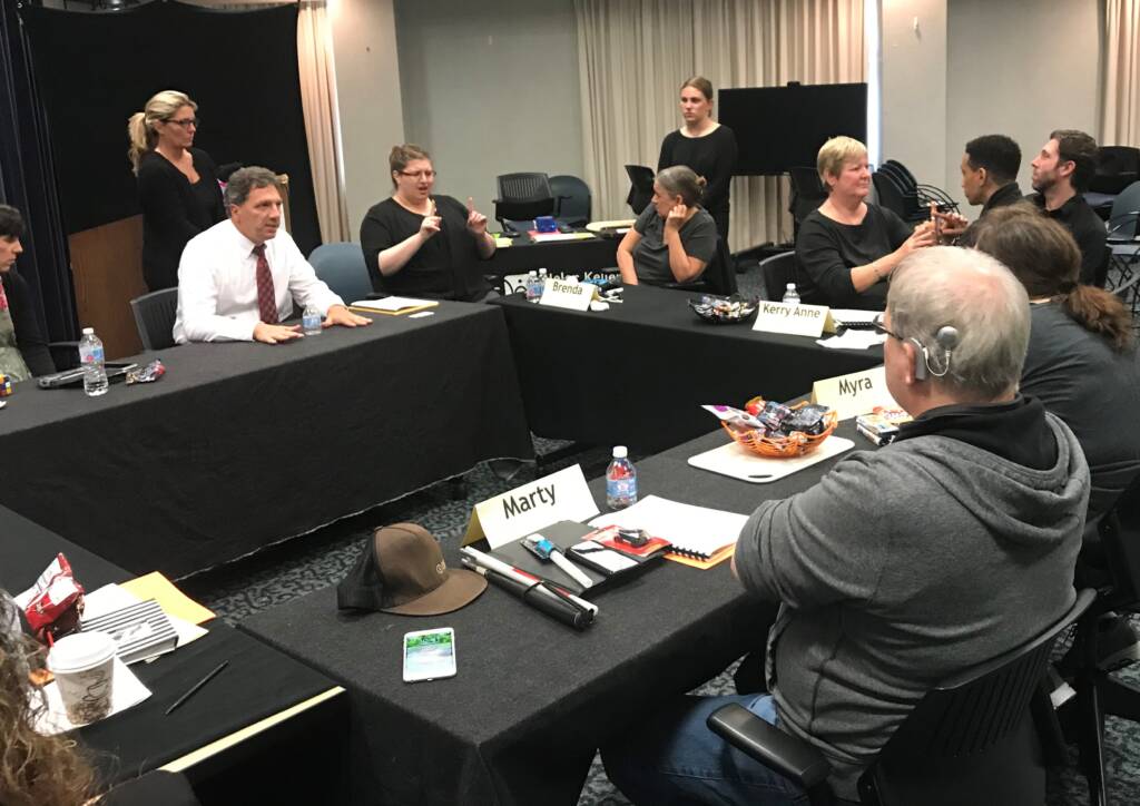 Group of people sitting at tables in training room