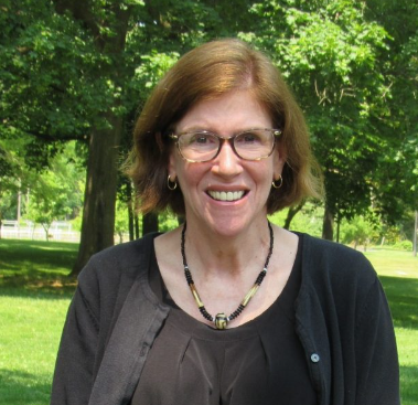 Deborah Harlin standing outside, wearing black, and smiling into the camera
