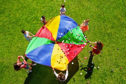 Children using parachute with balls.