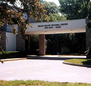 Front entrance of building with a sign that says “Helen Keller National Center For Deaf - Blind Adults”