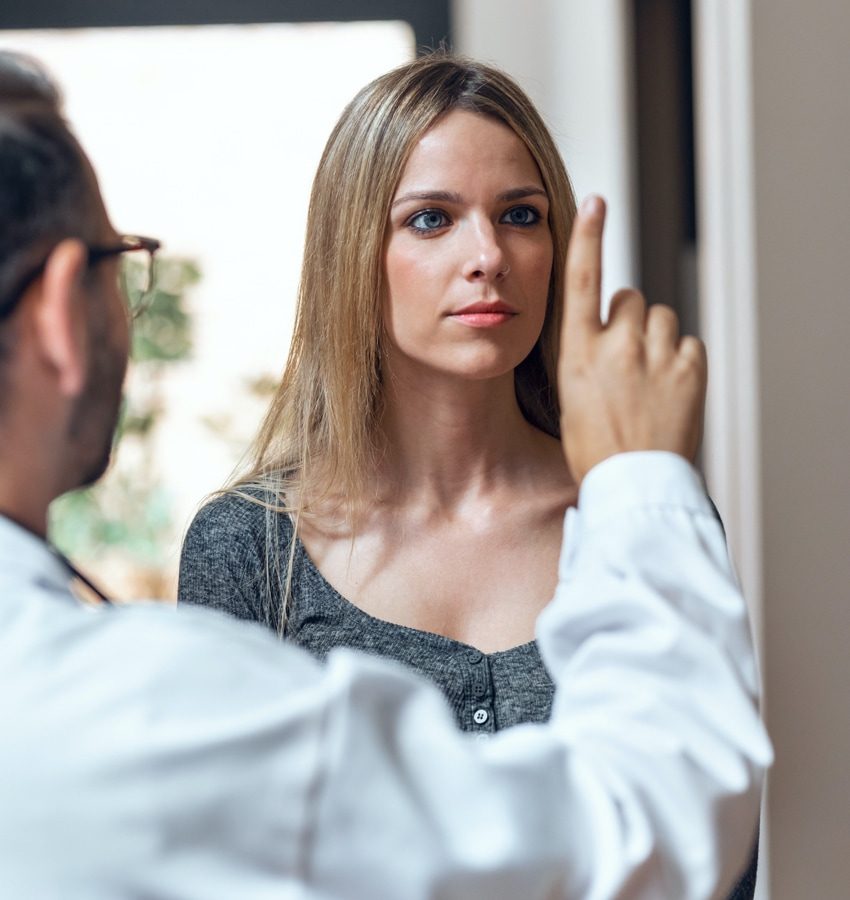 Woman looking at male doctor’s right extended pointer finger