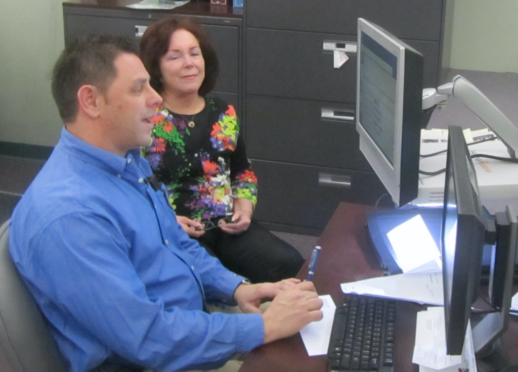 A man and a woman looking at a computer screen