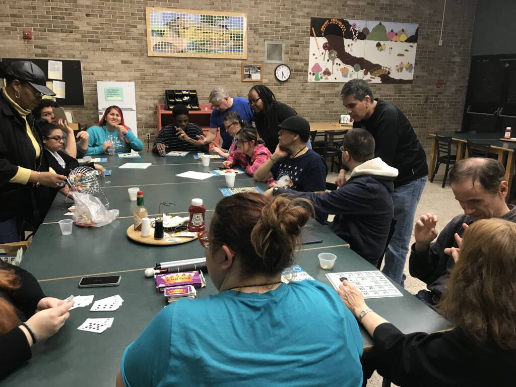 Group of men and women playing bingo and card games in a room