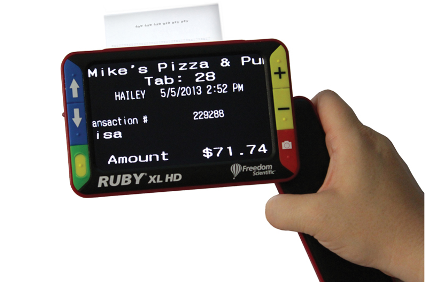 Person holding a Ruby handheld video magnifier that shows an enlarged pizza receipt on the screen