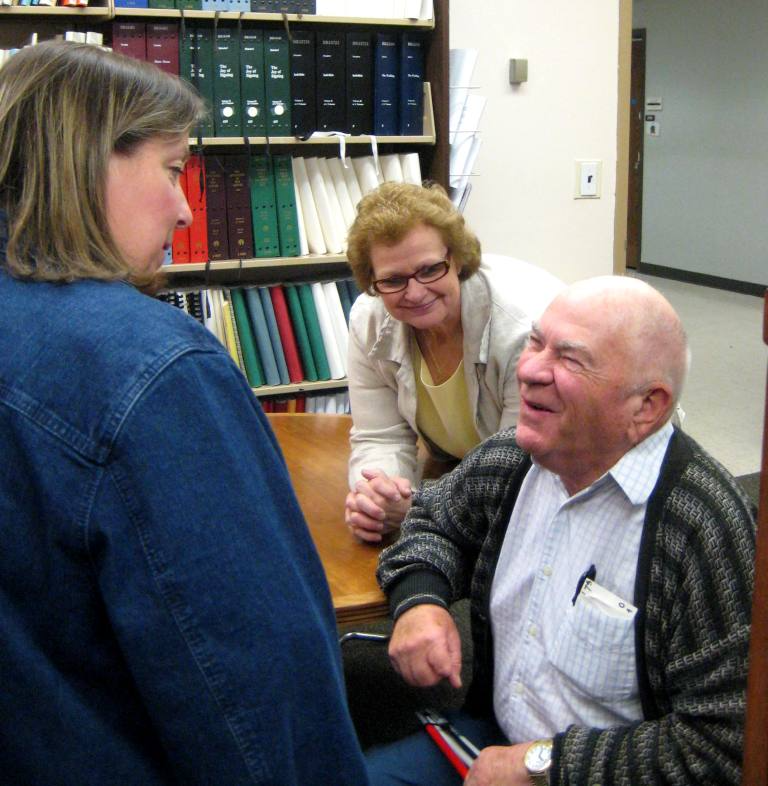An older man smiling near two women