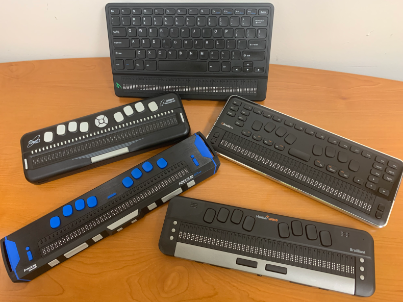 Five braille displays on a table