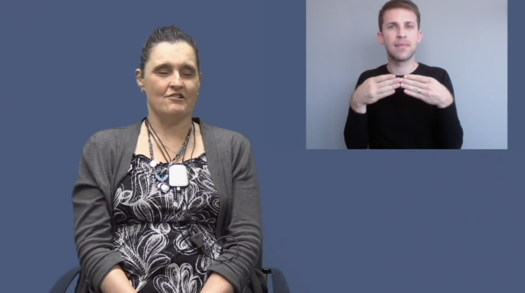A woman wearing dressy clothing and a man signing