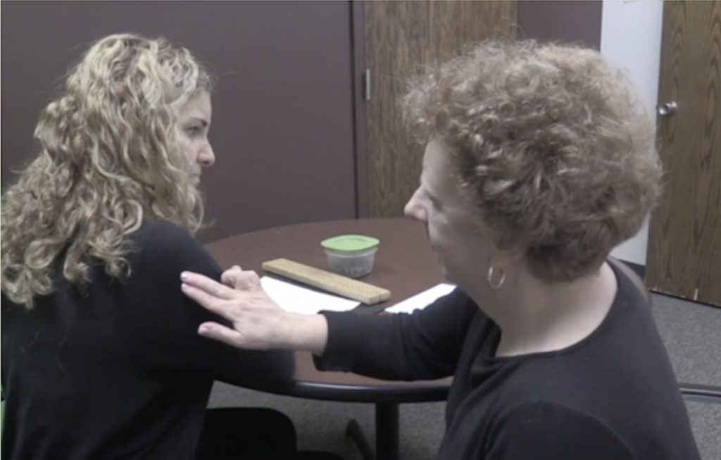 Two women engaging in tactile sign at a table