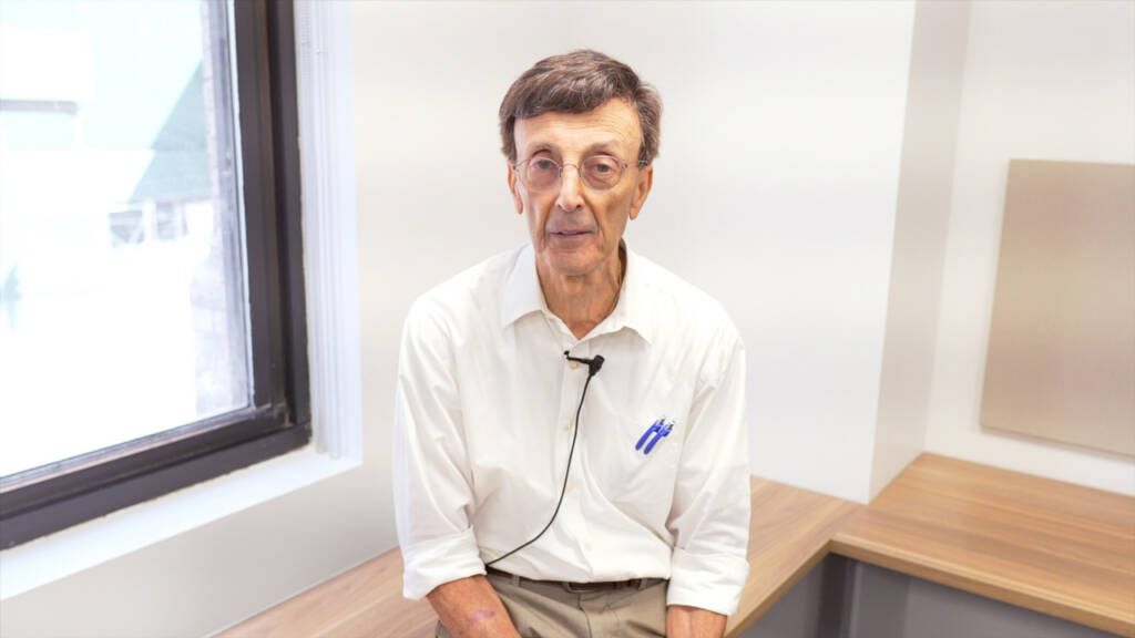 Man looking into the camera wearing glasses and a white collared shirt