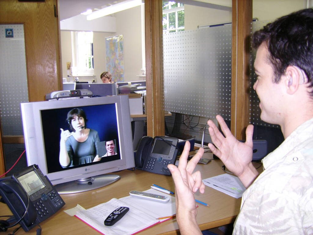 A man signing with a woman on a video call
