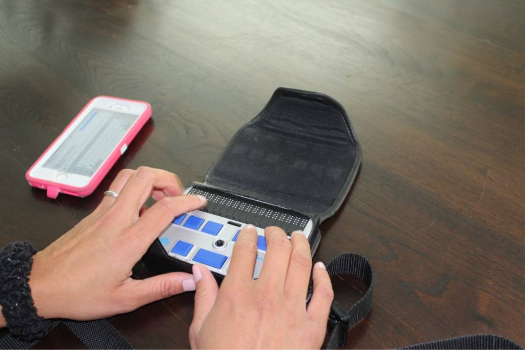 Una persona usa un dispositivo de Braille en combinación con un iPhone