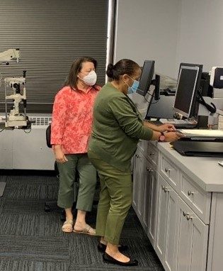 Two women in a room near computer monitors