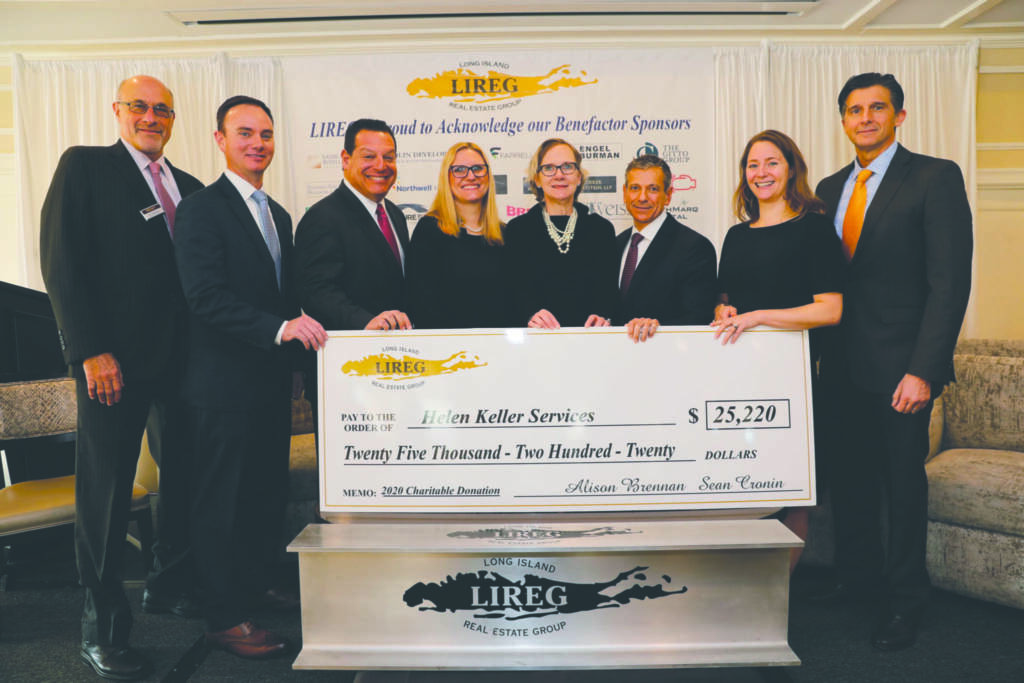 5 men and 3 women smiling and holding a large check from Long Island Real Estate Group for $25,220.