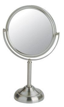 A circular mirror  on a silver stand