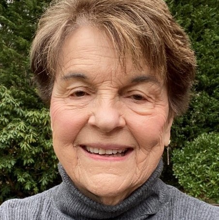 Head shot of a white woman with short brown hair wearing a gray turtleneck sweater.