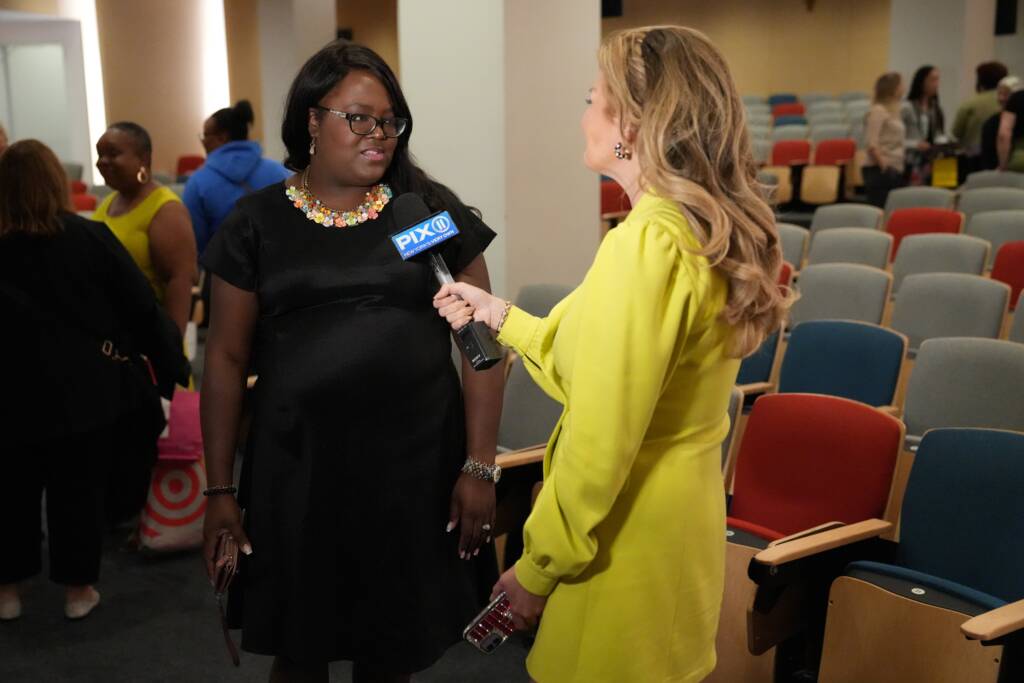 Principal Avien Henry talks to Newscaster Monica Morales in an auditorium at the Children's Learning Center graduation