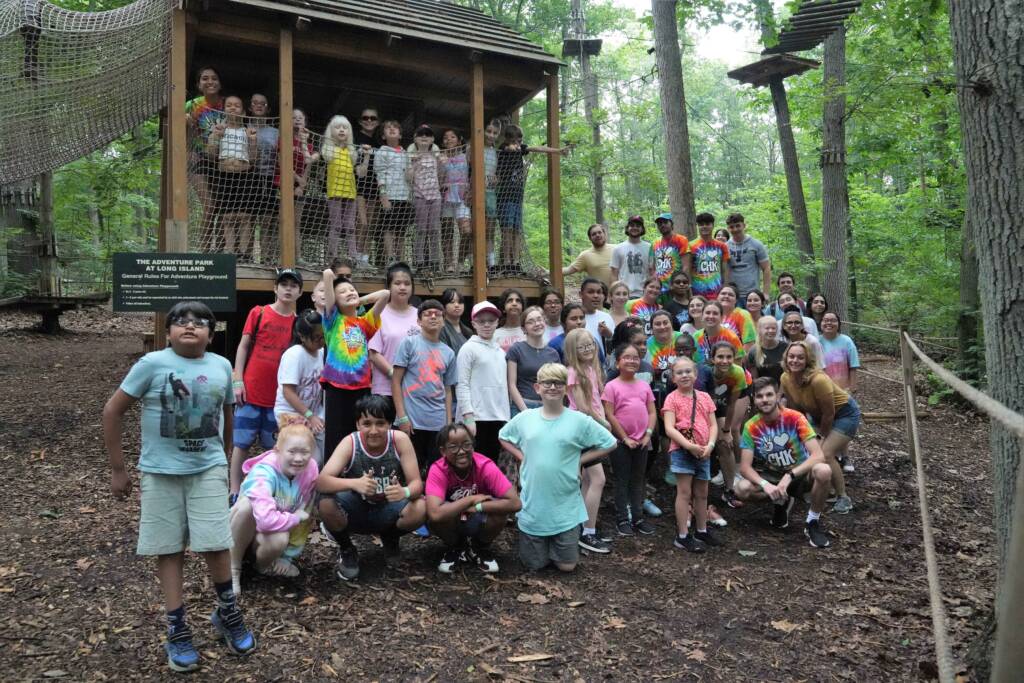 A large group of children who are blind and have low vision stand outside at The Adventure Park at Long Island