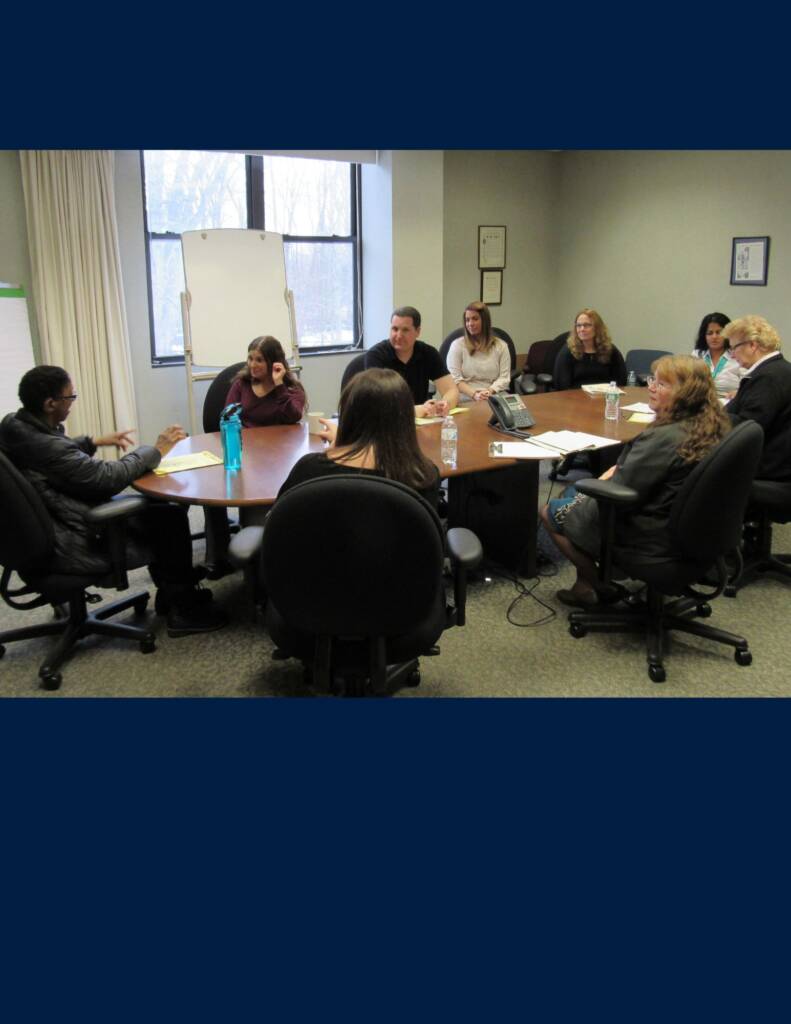 A group of people sitting around a large conference table