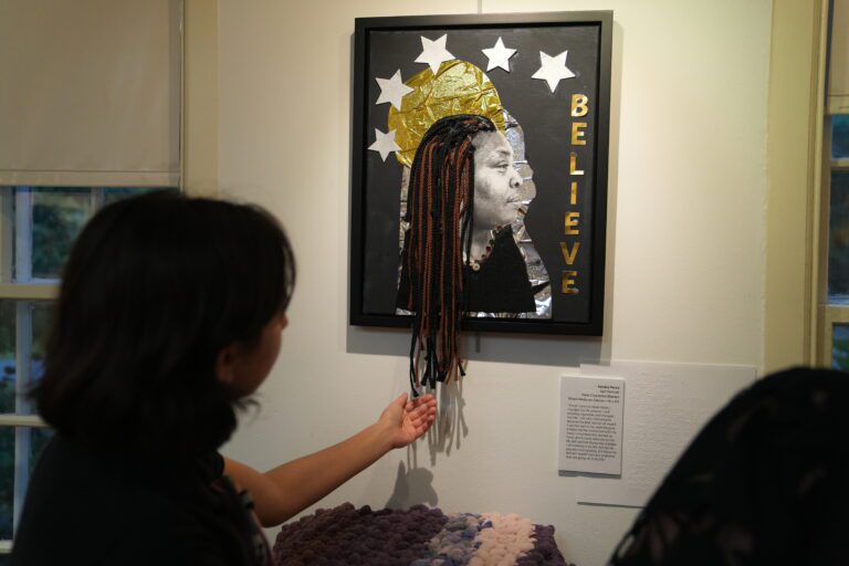 A patron touching an art piece at The Art Guild exhibit.
