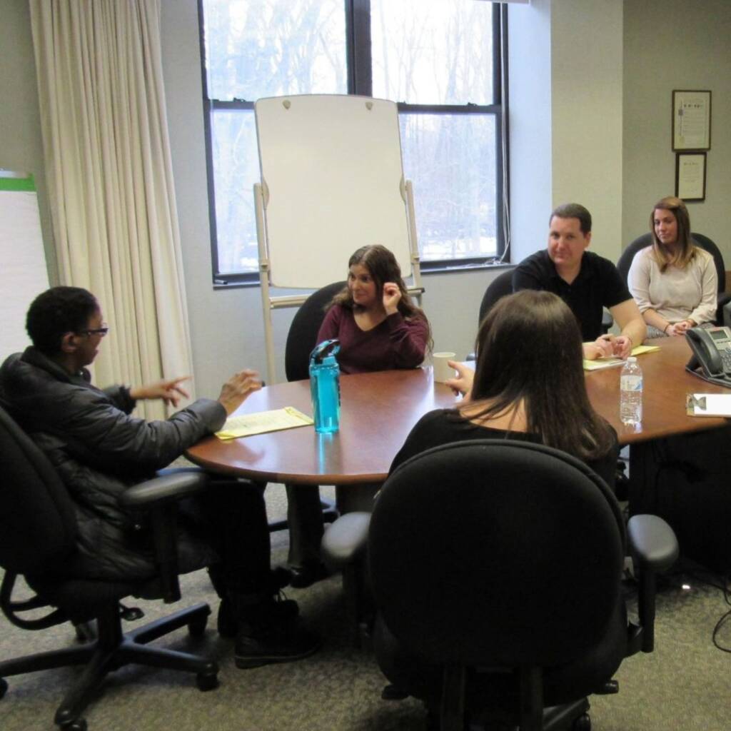 A group of people sitting around a large conference table