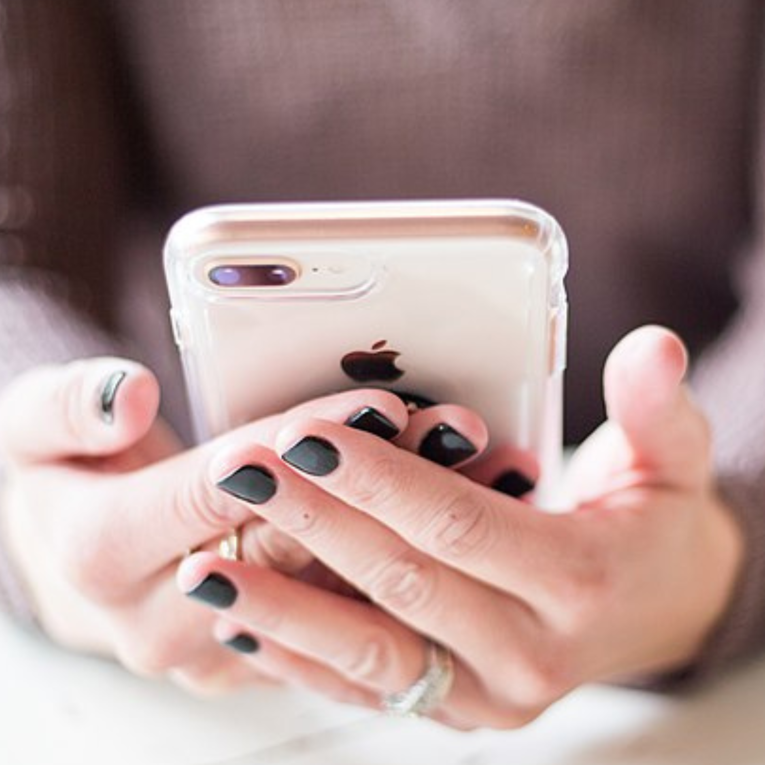 a close up of someone's hands holding an iPhone