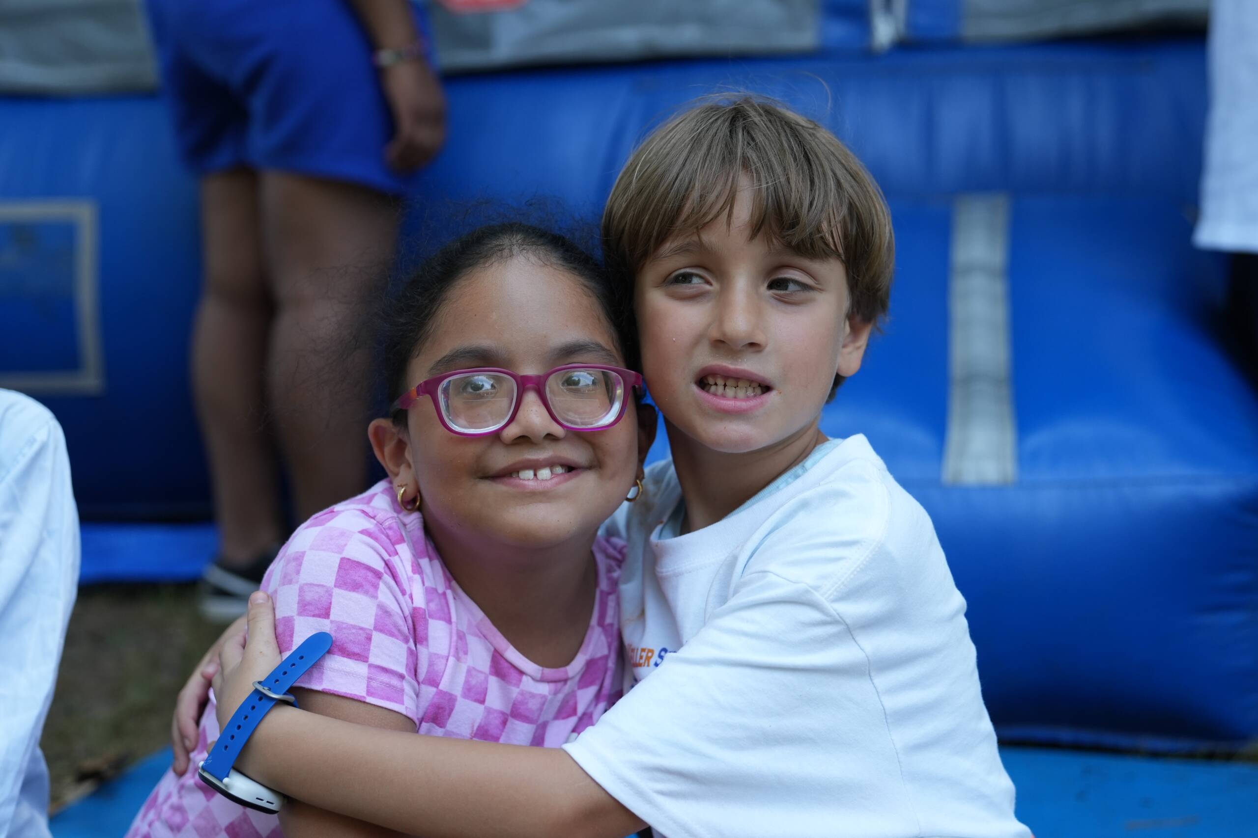 Two young campers hugging and smiling