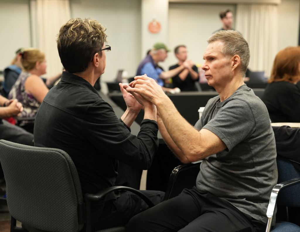 a man touches the hands of someone who does tactile sign language