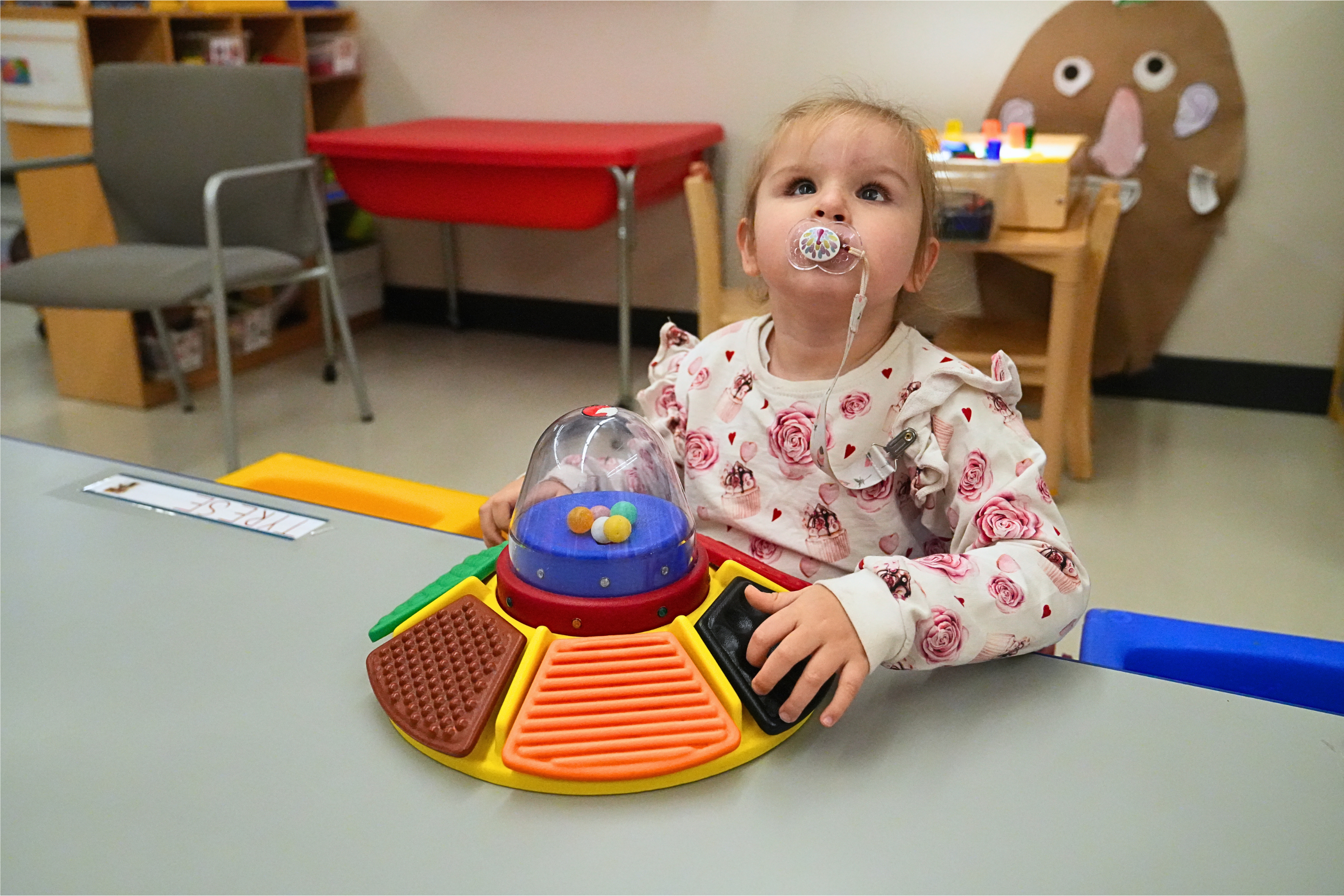 A preschool girl plays with a sensory toy in a Children's Learning Center classroom.