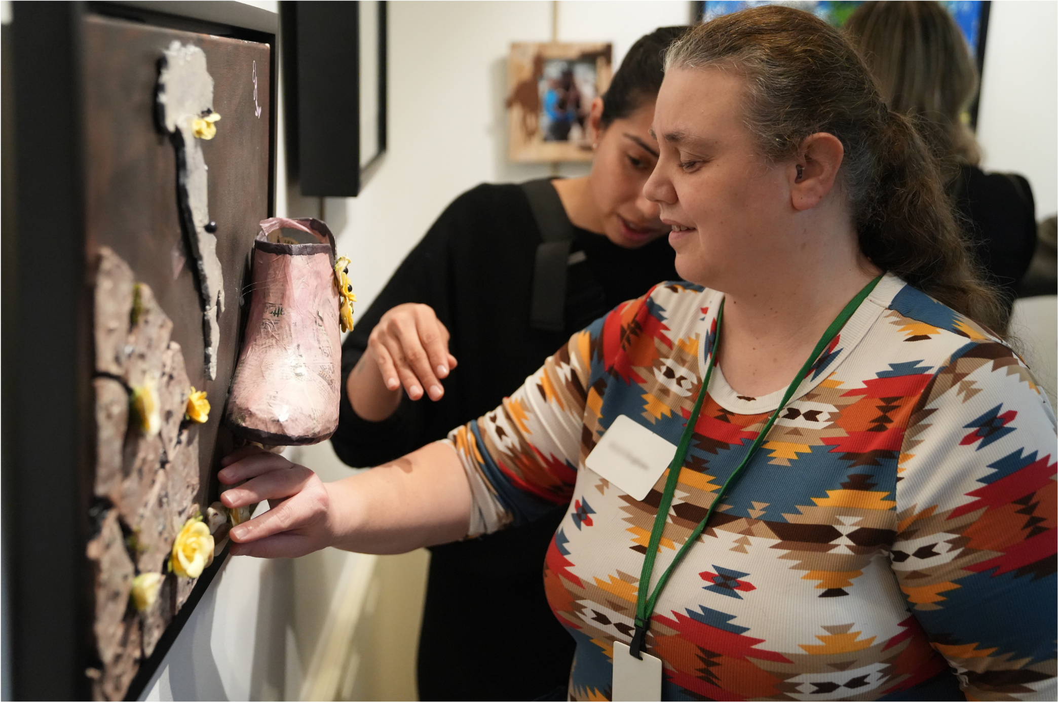 A woman touching art at a tactile art exhibition