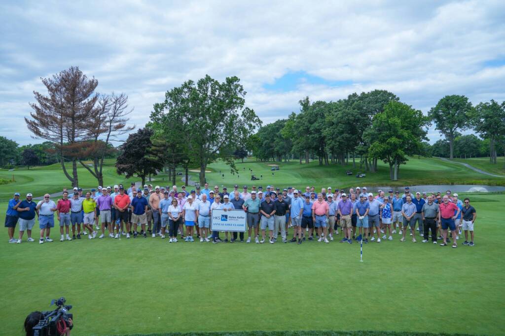 Group photo of Helen Keller Services Annual Golf Classic participants standing on the putting green. 