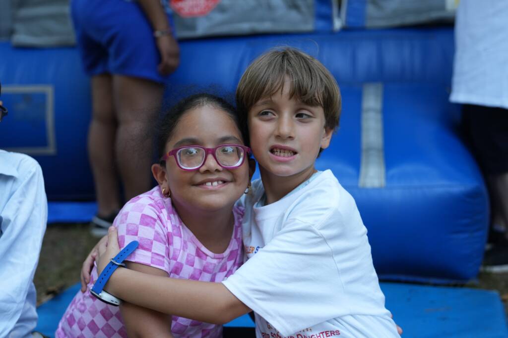 Boy and girl camper friends pose together for a photo.