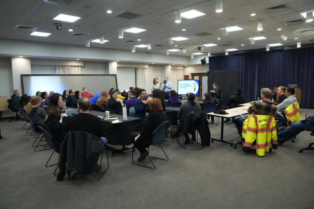 A large group of individuals including HKNC staff, participants and traffic engineers attend a workshop given by Polara representatives. 