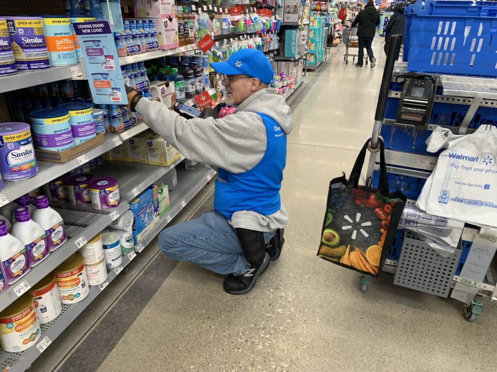 Troy looks for items on the shelves of a Walmart store.  