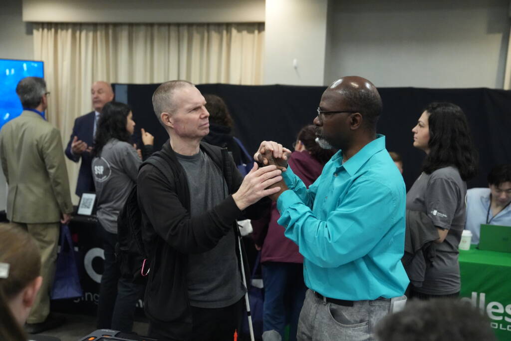 An attendee communicates with an interpreter during Tech Blitz.