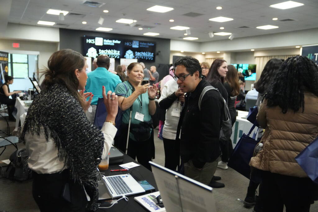 Attendees engage with a vendor in a crowded event.