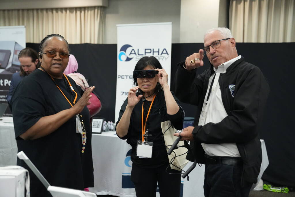 Attendee tries on Alpha Sensory gasses while Regional Rep Cynthia stands beside her.