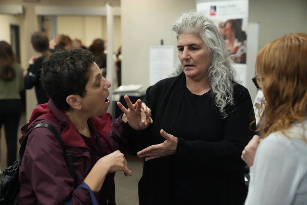 An attendee communicates with an interpreter in tactile ASL during Tech Blitz.