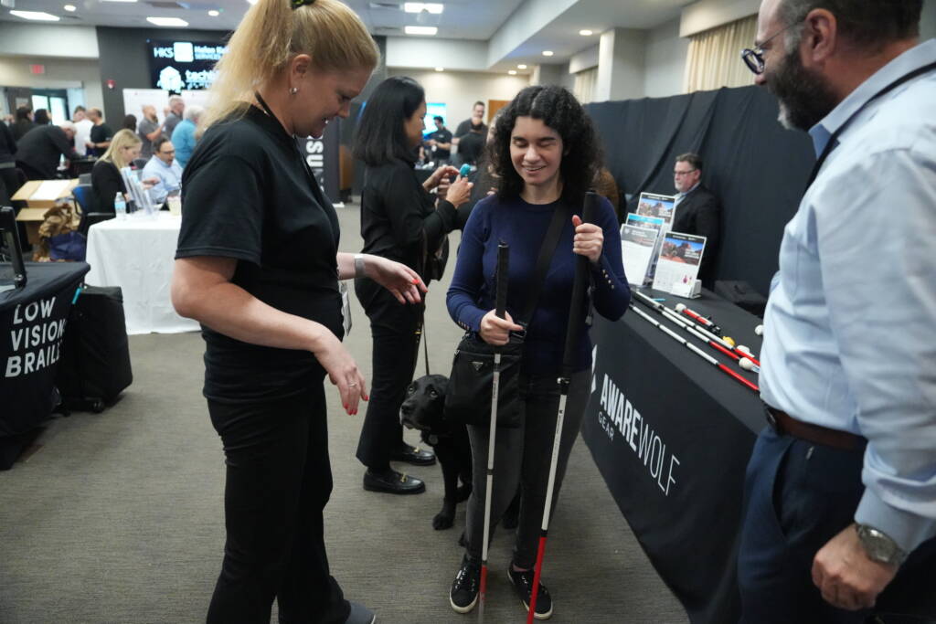 HKNC technology instructor Caitlin examines a new white cane from Awarewolf.