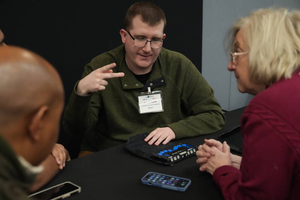 Bryan Ward signing in ASL while using a braille display.
